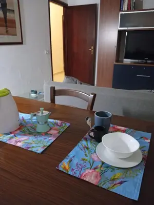 a wooden table with a plate and aucer on it at Mondello La Piazzetta Apartment in Palermo