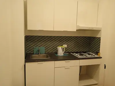 a small kitchen with a sink and a stove at Mondello La Piazzetta Apartment in Palermo