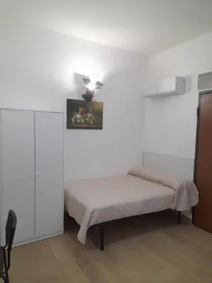 a bedroom with two beds and a painting on the wall at Makihome in Palermo