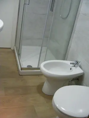 a bathroom with a white toilet and a shower at Makihome in Palermo