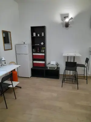 a room with tables and chairs and a refrigerator at Makihome in Palermo