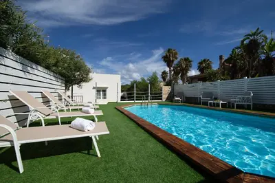 a swimming pool with lounge chairs and a swimming pool at Villa Charme in San Vito lo Capo