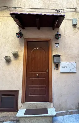 a wooden door on the side of a building at Bacio del sole Apartment in Palermo