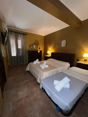 a hotel room with two beds with white sheets at Bacio del sole Apartment in Palermo
