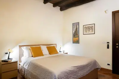 a bedroom with a bed with two orange pillows at I Carrettieri - a few steps from the Cathedral in Palermo