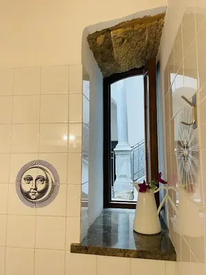 a window in a bathroom with a vase on a window sill at I Carrettieri - a few steps from the Cathedral in Palermo