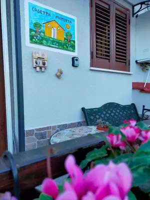 a table and flowers in front of a house at Casetta Matotta, casa vacanze a Mondello - Palermo in Mondello