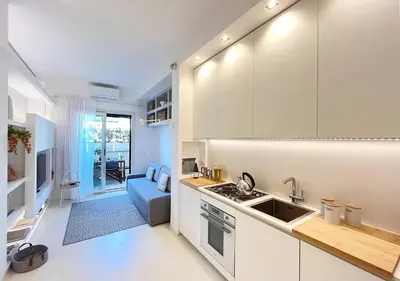 a kitchen with white cabinets and a blue couch at Solemar Sicilia - White Loft in Palermo