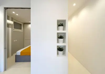 a bedroom with a bed and potted plants on a wall at Solemar Sicilia - White Loft in Palermo