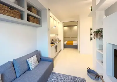 a living room with a blue couch and a bedroom at Solemar Sicilia - White Loft in Palermo