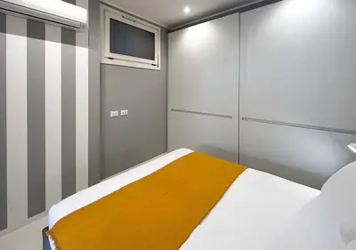 a bedroom with a bed with a yellow blanket at Solemar Sicilia - White Loft in Palermo