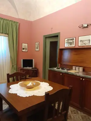 a dining room with a table and a kitchen at Casa Castelli Appartamento vacanza in Bagheria