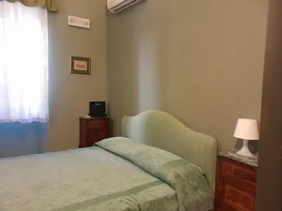 a bedroom with a bed and a lamp and a window at Casa Castelli Appartamento vacanza in Bagheria