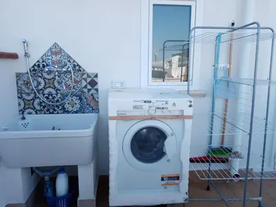 a washing machine in a bathroom next to a sink at La Terrazza Solarium, in pieno centro 60m dalla stazione ferroviaria 700m dal mare in Santa Flavia