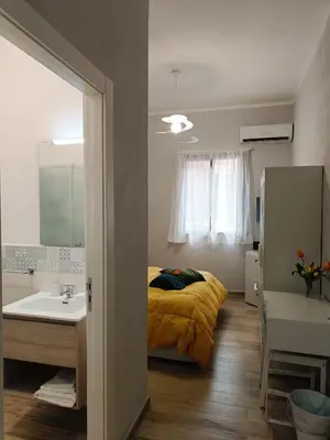 a bedroom with a bed and a sink and a mirror at NONNO PEPPE Suites 1, 2 & 3 in Terrasini