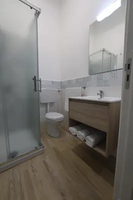 a bathroom with a sink and a toilet and a mirror at NONNO PEPPE Suites 1, 2 & 3 in Terrasini