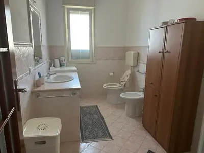 a bathroom with a sink and a toilet and a window at Casetta Sferracavallo in Palermo