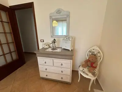a teddy bear sitting in a chair next to a dresser at Casetta Sferracavallo in Palermo