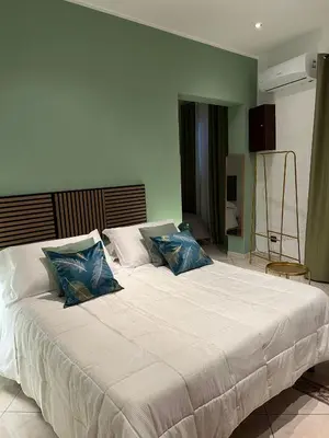 a bedroom with a large white bed with blue pillows at la porta di Alba in Palermo