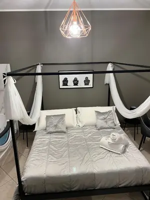 a bedroom with a bed with a canopy and curtains at la porta di Alba in Palermo