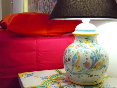 a vase sitting on a table next to a lamp at In Itinera in Palermo