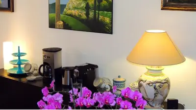 a lamp sitting on a table with purple flowers at In Itinera in Palermo
