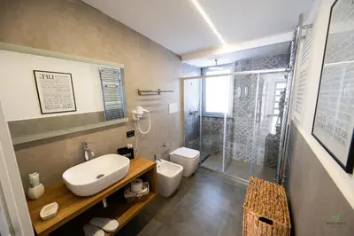 a bathroom with a sink and a toilet and a shower at New River Hotel in Borgetto