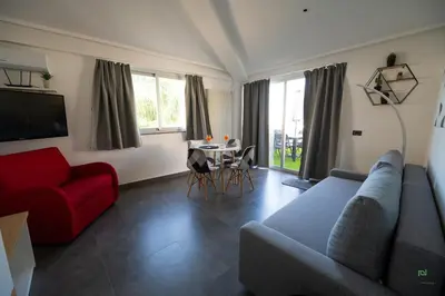 a living room with a red couch and a table at New River Hotel in Borgetto