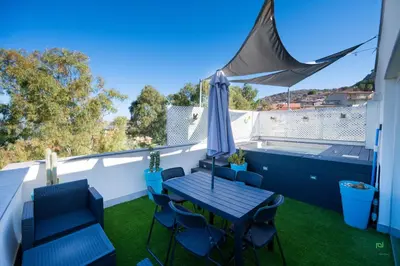 a balcony with a table and chairs and an umbrella at New River Hotel in Borgetto