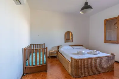 a bedroom with a bed and a crib in it at Casa Margherita Cefalù - Villa con accesso privato al mare in Cefalù