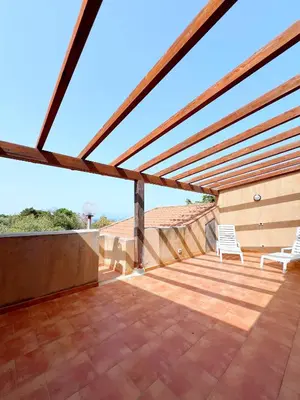 a pergola with two chairs on a patio at Casa Margherita Cefalù - Villa con accesso privato al mare in Cefalù