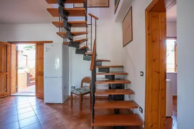 a spiral staircase in a room with a refrigerator at Casa Margherita Cefalù - Villa con accesso privato al mare in Cefalù