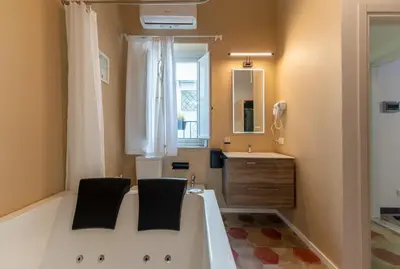 a bathroom with a tub and a sink and a mirror at Regina Suite in Palermo