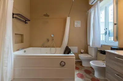 a bathroom with a large tub and a toilet at Regina Suite in Palermo