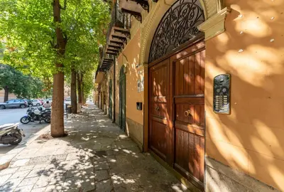 a building with a wooden door on the side of a street at Regina Suite in Palermo