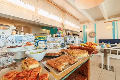 a bakery with many different types of food on a counter at Marina di Petrolo Apartments in Castellammare del Golfo