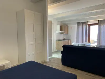 a living room with a couch and a kitchen at Marina di Petrolo Apartments in Castellammare del Golfo
