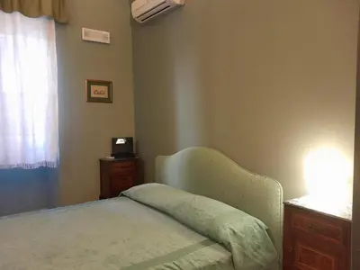 a bedroom with a bed and a dresser and a window at Casa Castelli Holiday Apartment in Bagheria
