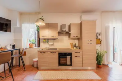 a small kitchen with wooden cabinets and a table at Casa Marina in Palermo