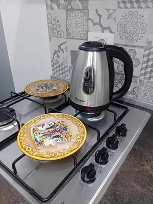 a coffee pot and two plates on a stove at Casa Mauro in Palermo