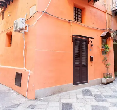 an orange building with a door and a window at Casa Mauro in Palermo