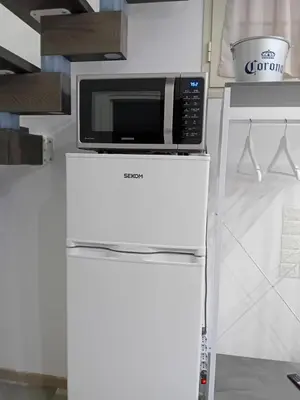a microwave on top of a refrigerator in a kitchen at Casa Mauro in Palermo