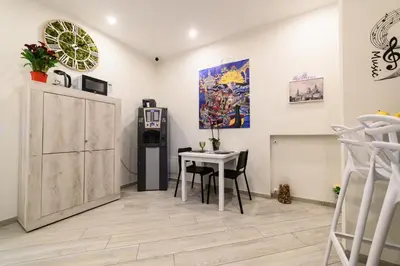 a dining room with a table and a refrigerator at Le terrazze di Giulia in Palermo
