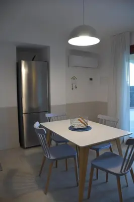 a kitchen with a table and chairs and a refrigerator at Caladdaura in Palermo