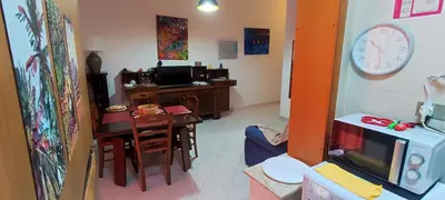 a living room with a dining room table and a clock at Abba Palermo centro in Palermo