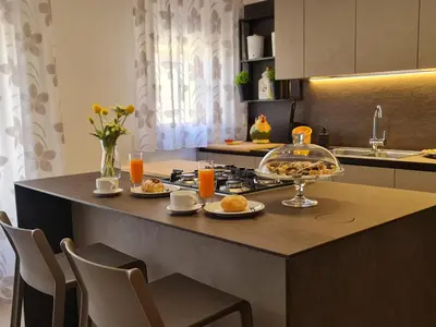 a kitchen with a table with food and orange juice at Casa Zolì - Luxury House - 210mq in Palermo