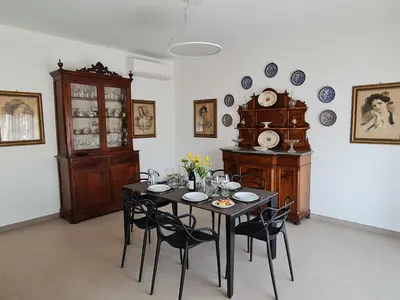 a dining room with a table with chairs and a clock at Casa Zolì - Luxury House - 210mq in Palermo