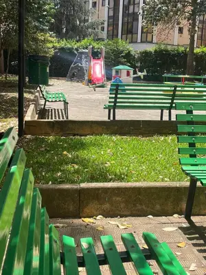 a park with green park benches and a playground at Sara House Palermo in Palermo
