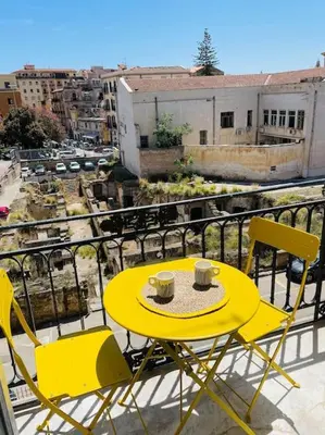 a yellow table and chairs on a balcony at Monkey house Appartamento in centro storico in Palermo