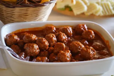 a white dish of meatballs and a bowl of sauce at Villa Lampedusa in Palermo